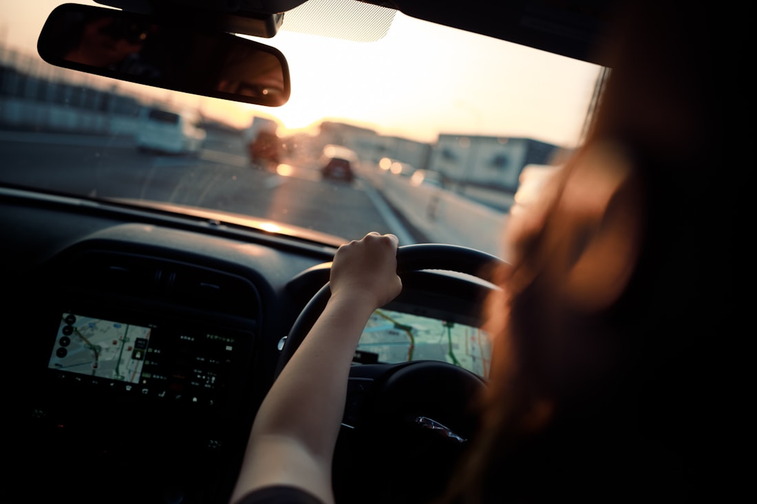 A confident learner driving independently on a Nottingham road at golden hour